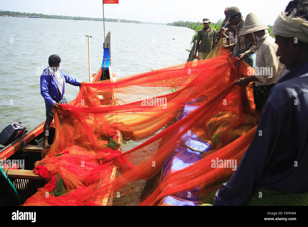 Fishermen cleaning fishnet ; Vypeen ; Cochin ; Kerala ; India Stock Photo
