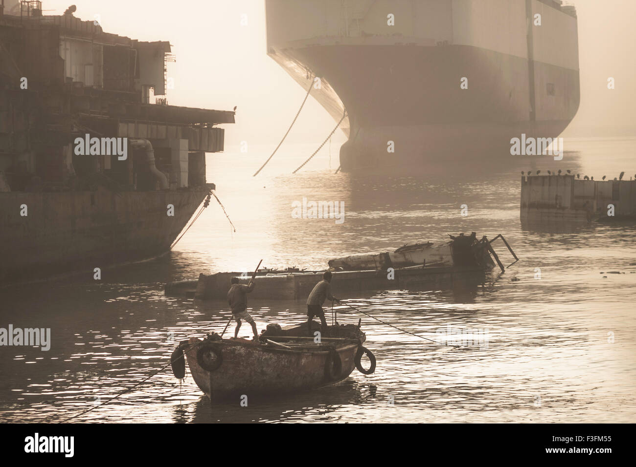 Shipbreaking Yards of Alang. Workers going onto a wreckage at dawn