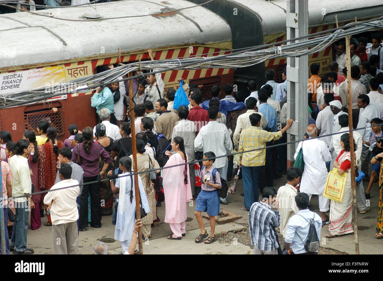 Commuters try to get into crowded local train during peak hour at Ghatkopar Railway Station Mumbai Stock Photo