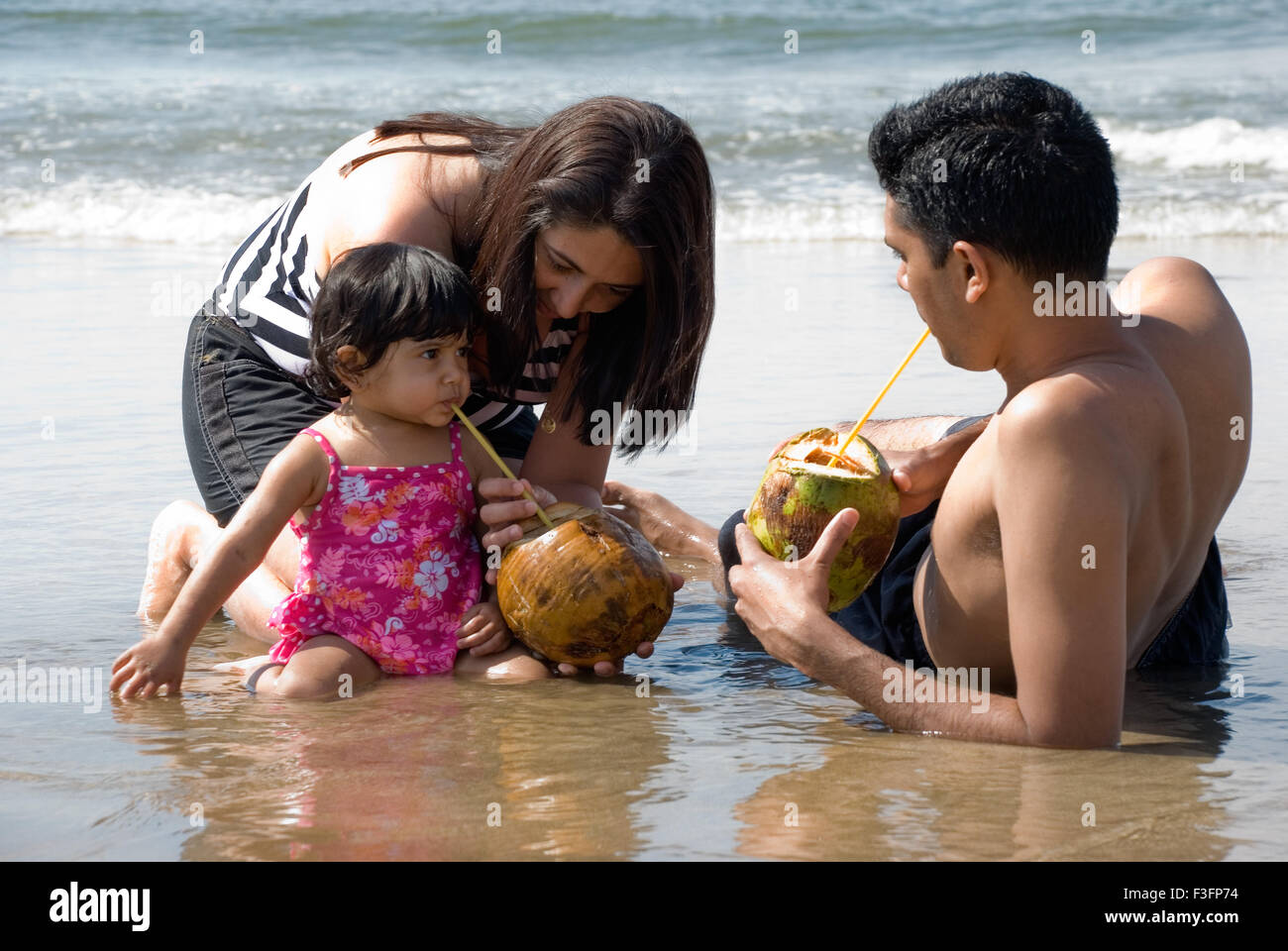 Family cooling off on the beach ; Mandre beach ; Goa ; India MR Stock Photo