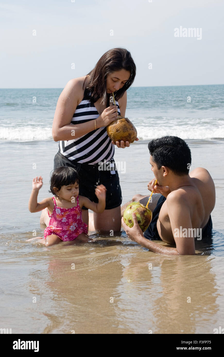 Family cooling off on the beach ; Mandre beach ; Goa ; India MR Stock Photo