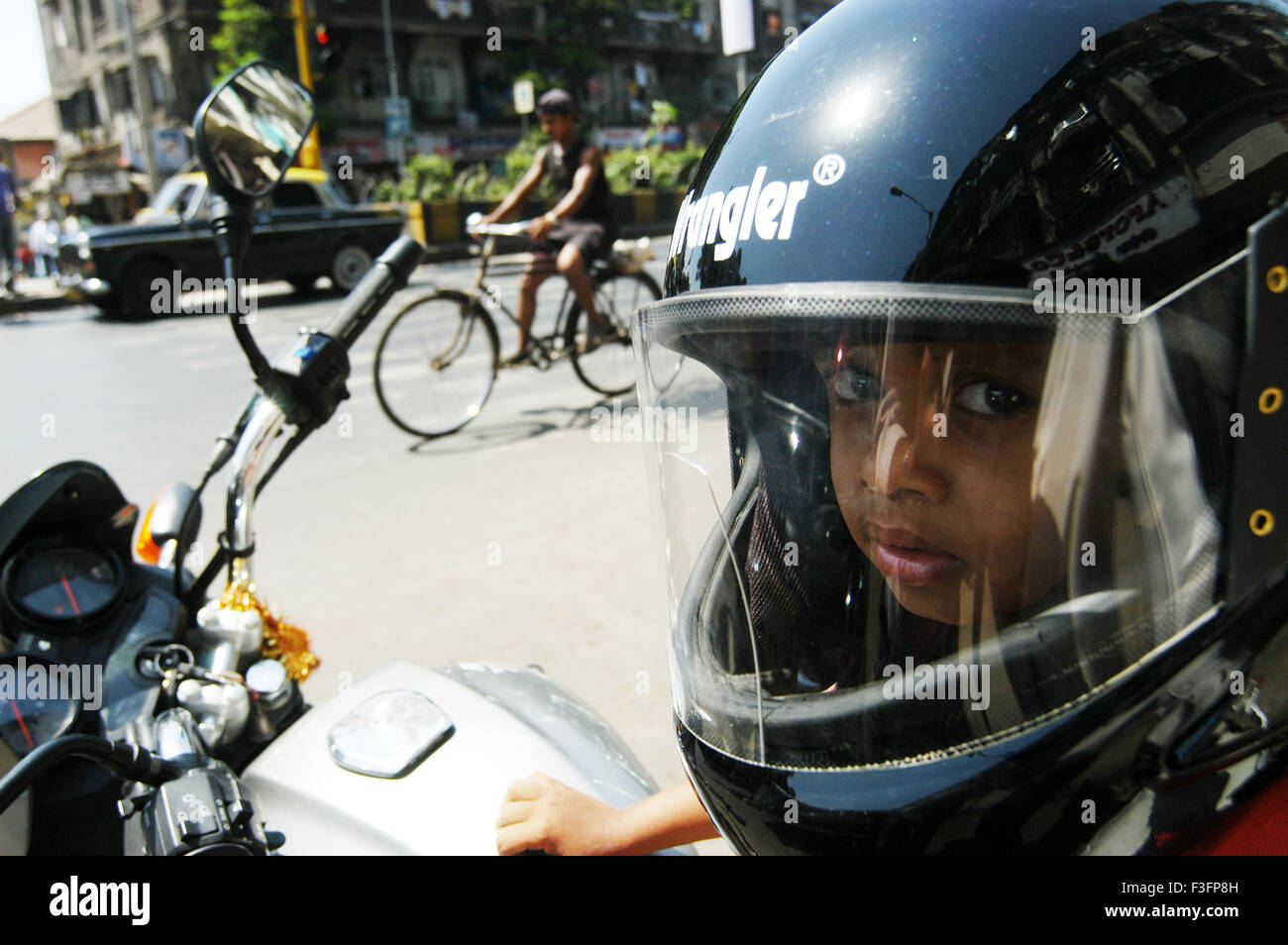 Boy wears helmet sits on two wheeler or motor bike in Bombay Mumbai ; Maharashtra ; India NO MR Stock Photo