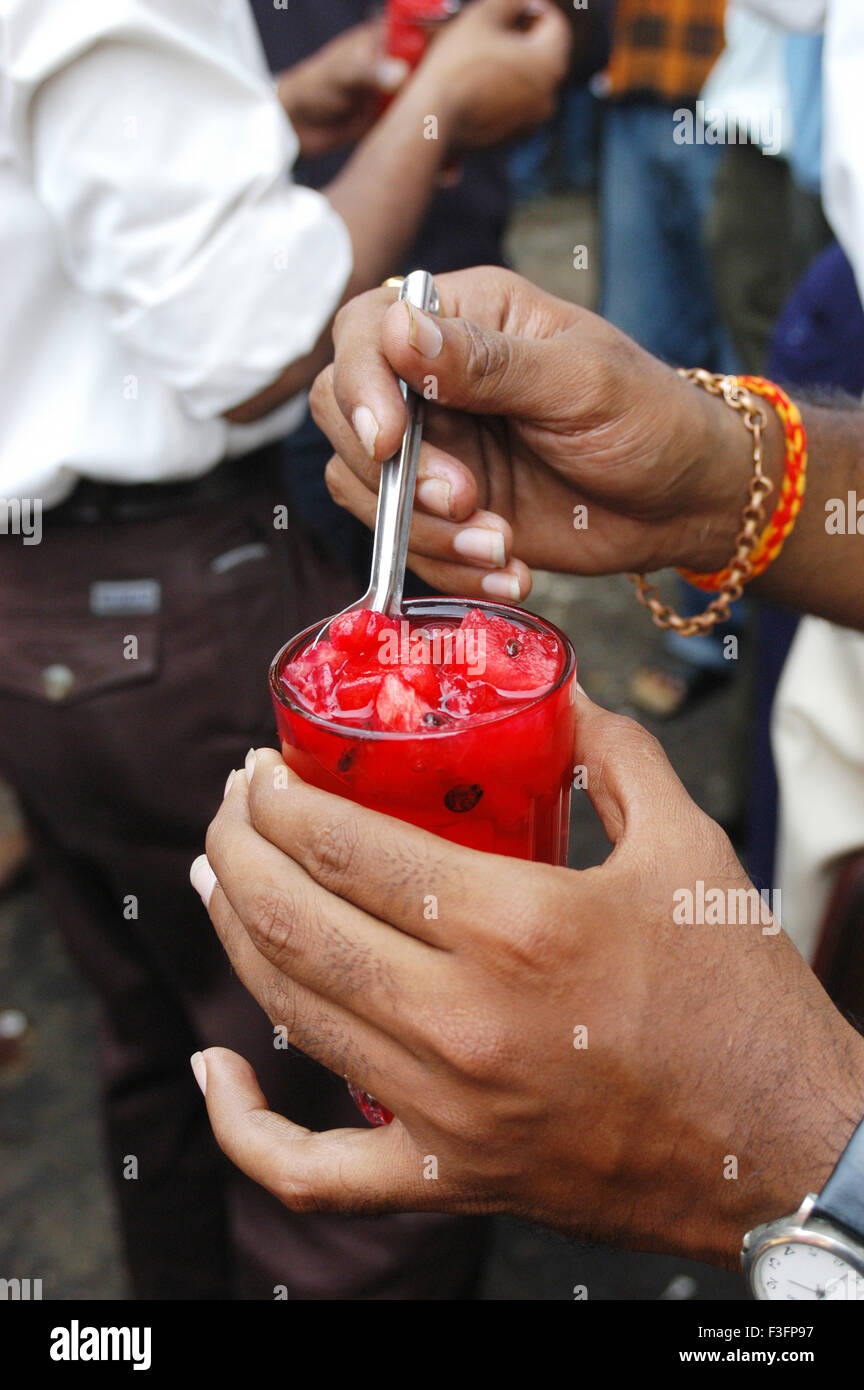 Customer drinks watermelon juice to beat summer heat in Bombay Mumbai ; Maharashtra ; India Stock Photo