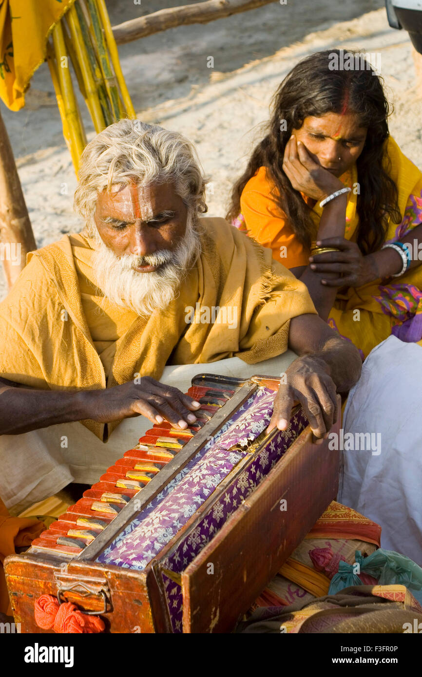 Hindu sadhu playing musical instrument harmonium ; India ; Asia Stock Photo