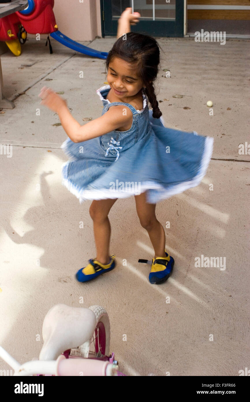 Four years old girl playing chakkar Stock Photo