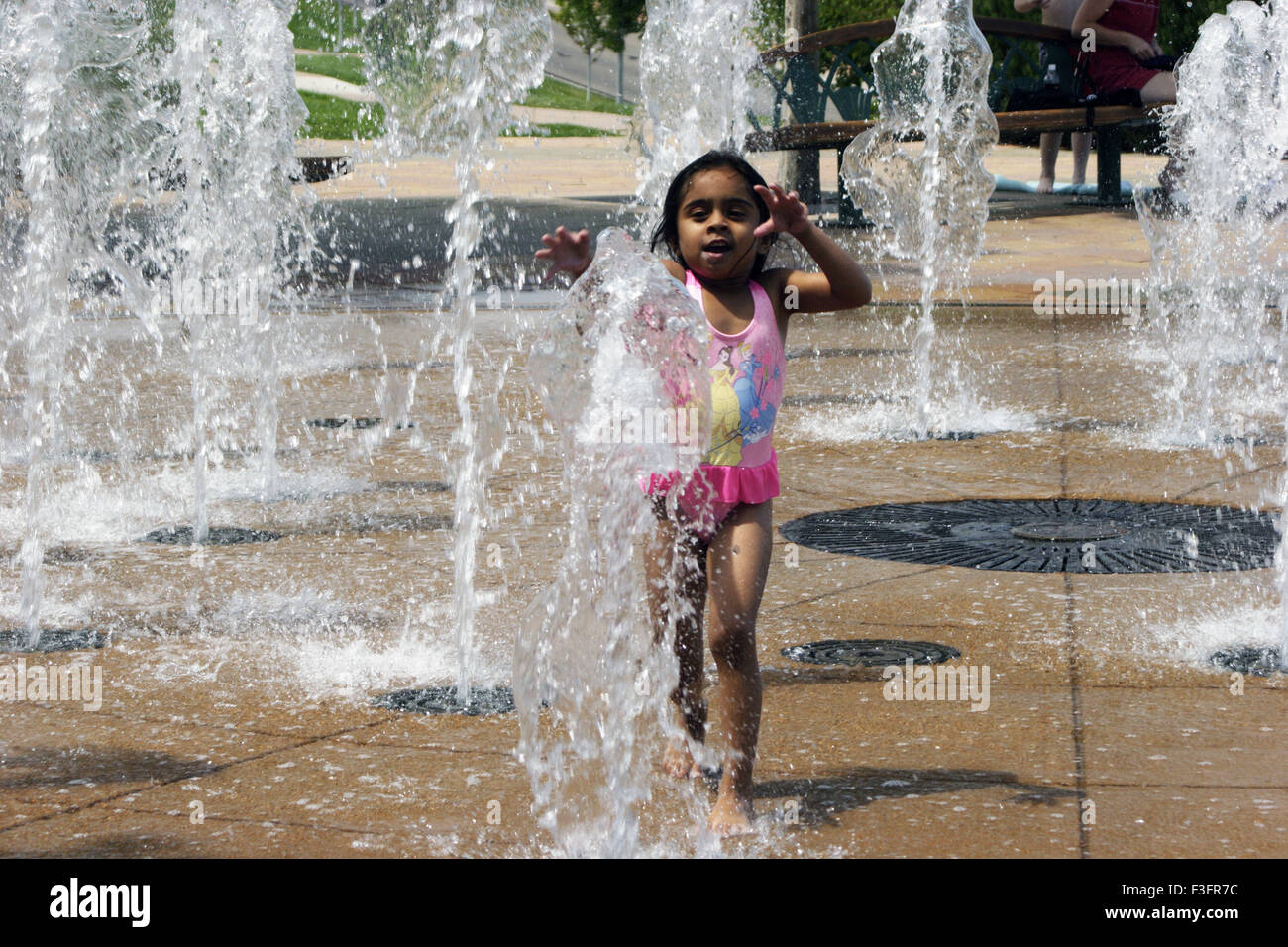 Four years old girl enjoying on fountain in summer day ; U.S.A. United States of America Stock Photo