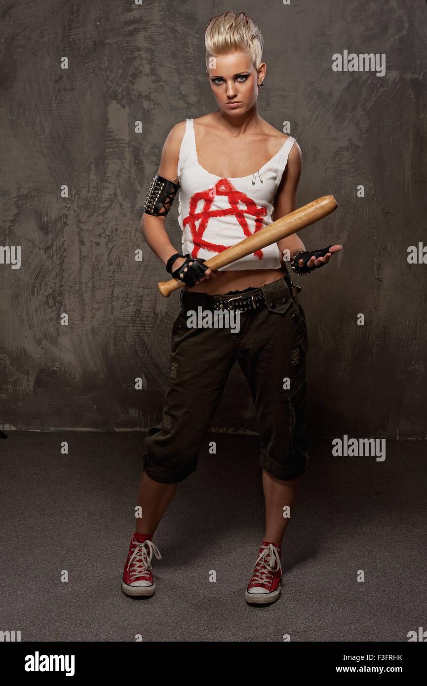 Punk girl with a baseball bat against grey background Stock Photo - Alamy