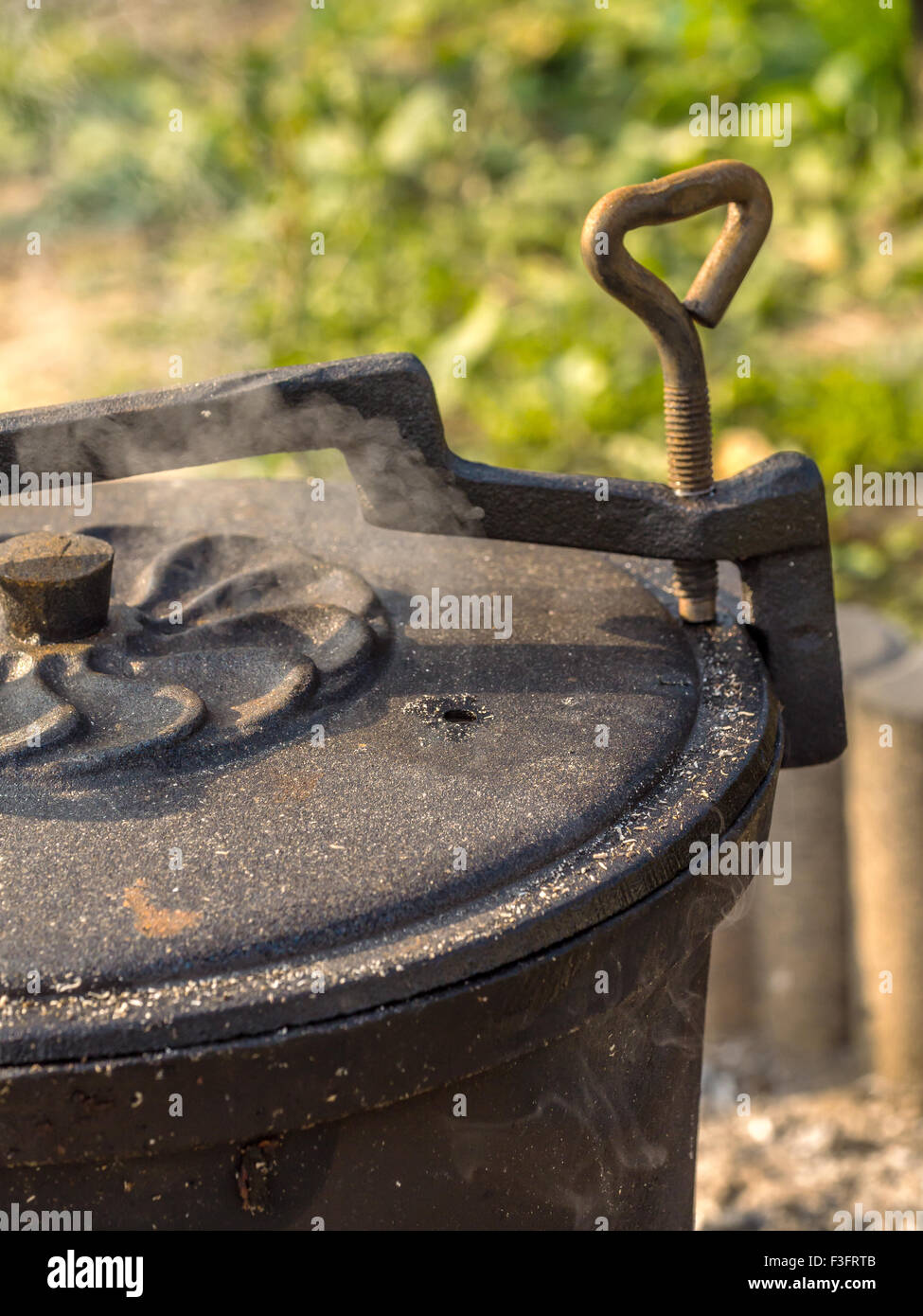 Black cast-iron kettle placed on fire Stock Photo
