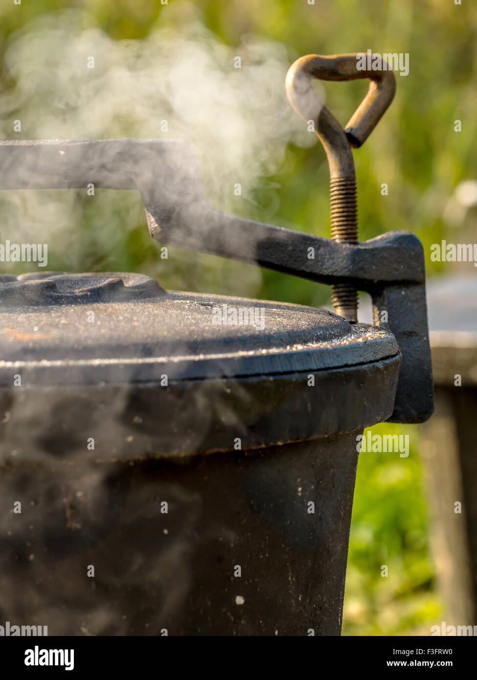 Black cast-iron kettle placed on fire Stock Photo