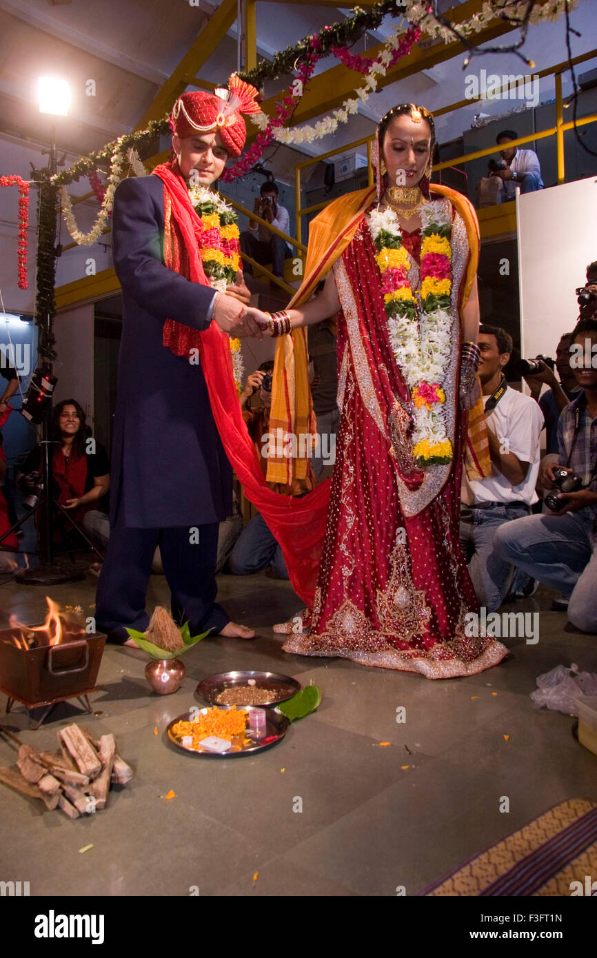 Indian bride and bridegroom holding hand taking round around holy fire ...