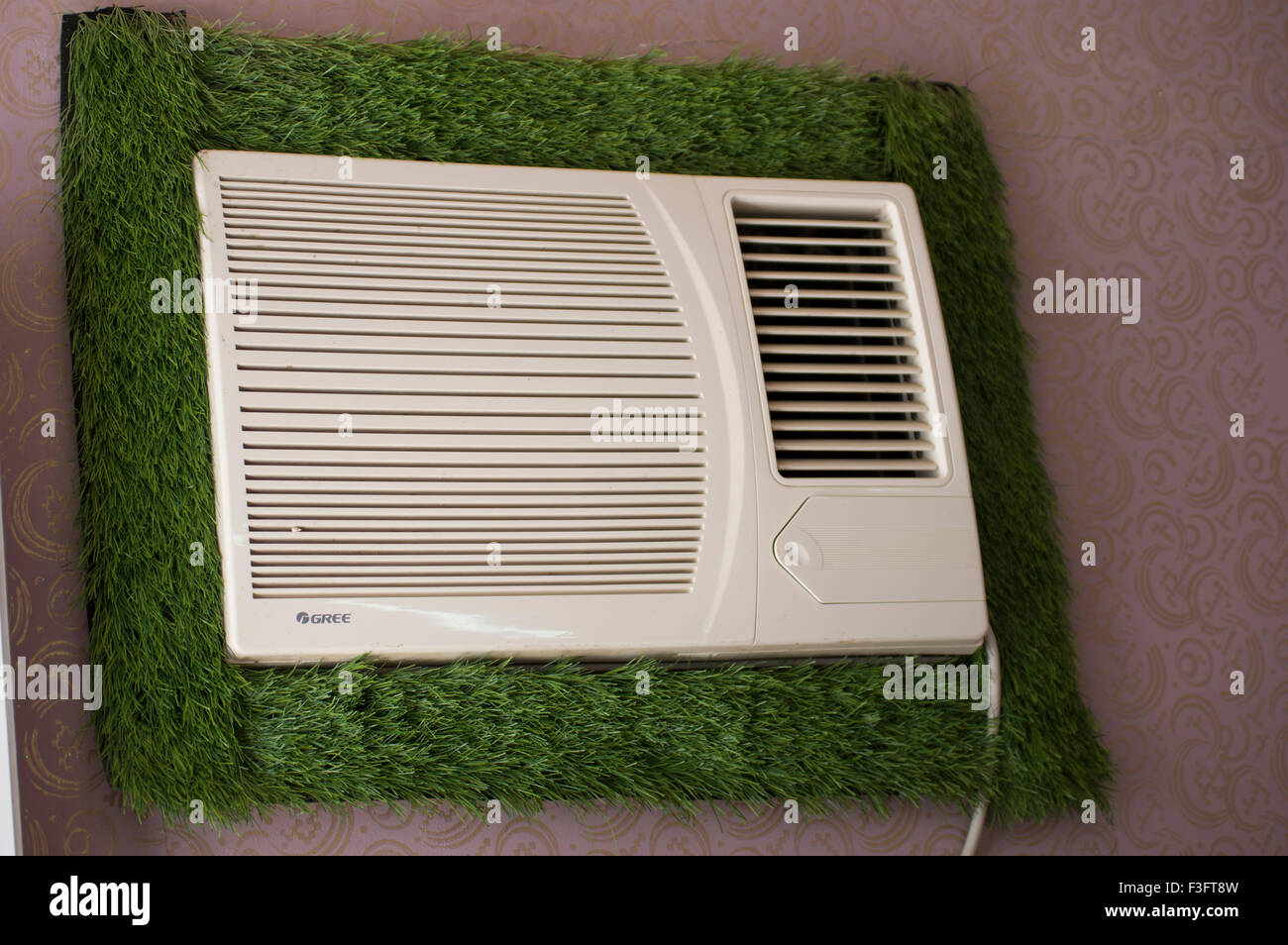 Astro turf framing an air conditioner in Oman. Stock Photo