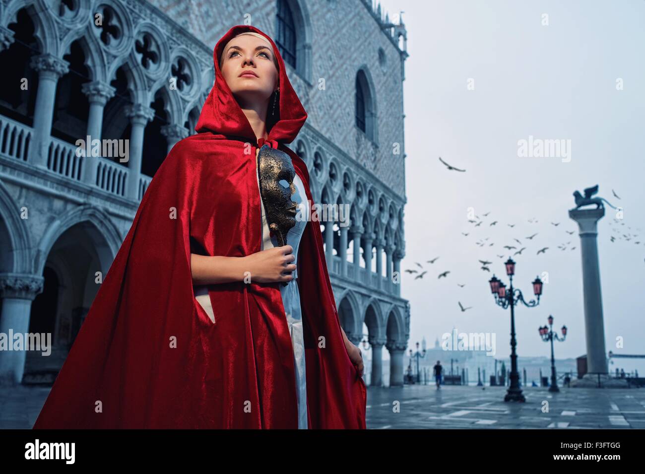 Beautiful woman in red cloak against Dodge's Palace Stock Photo