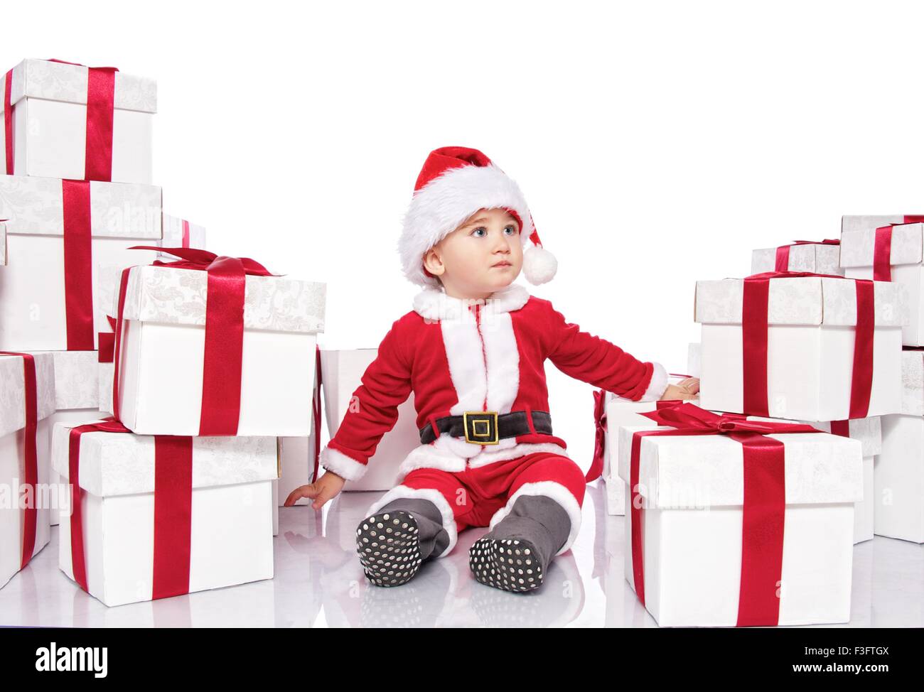 Baby boy in Santa Claus costume sitting between gift boxes Stock Photo ...