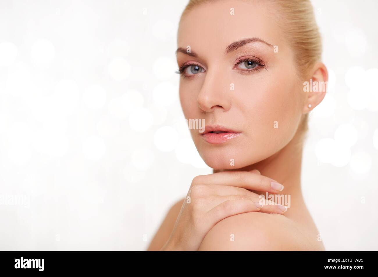 Beautiful woman touching her shoulder Stock Photo - Alamy