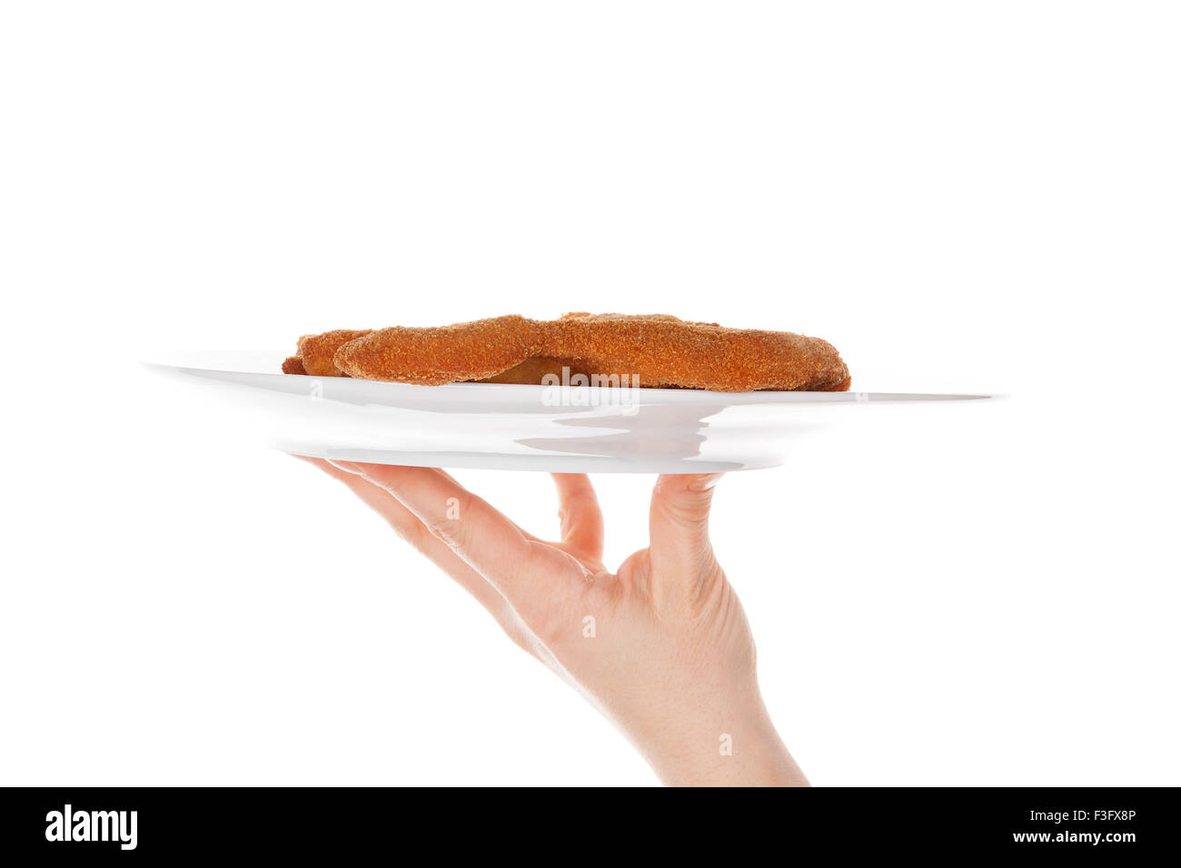 Female hand holding a plate with wiener schnitzel isolated on white background with reflection