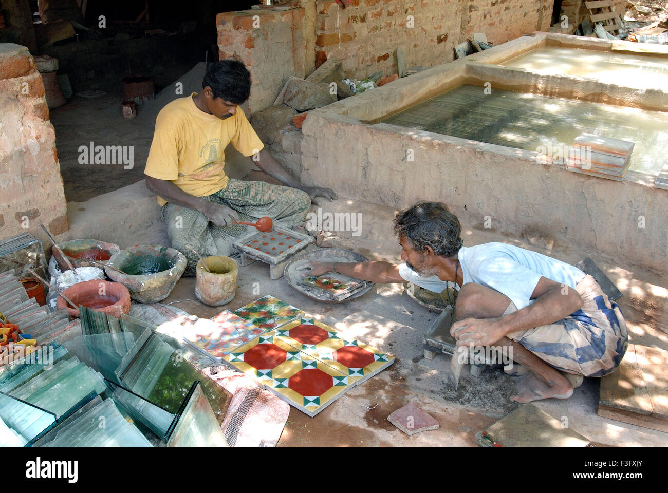 Man making Athangudi tiles which are not ceramic quite heavy and costly