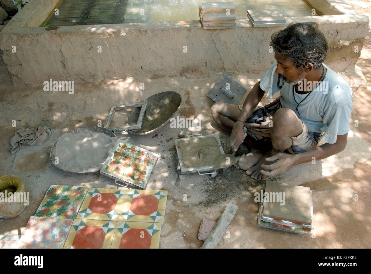 Man making Athangudi tiles which are not ceramic quite heavy and costly ; Tamil Nadu ; India Stock Photo