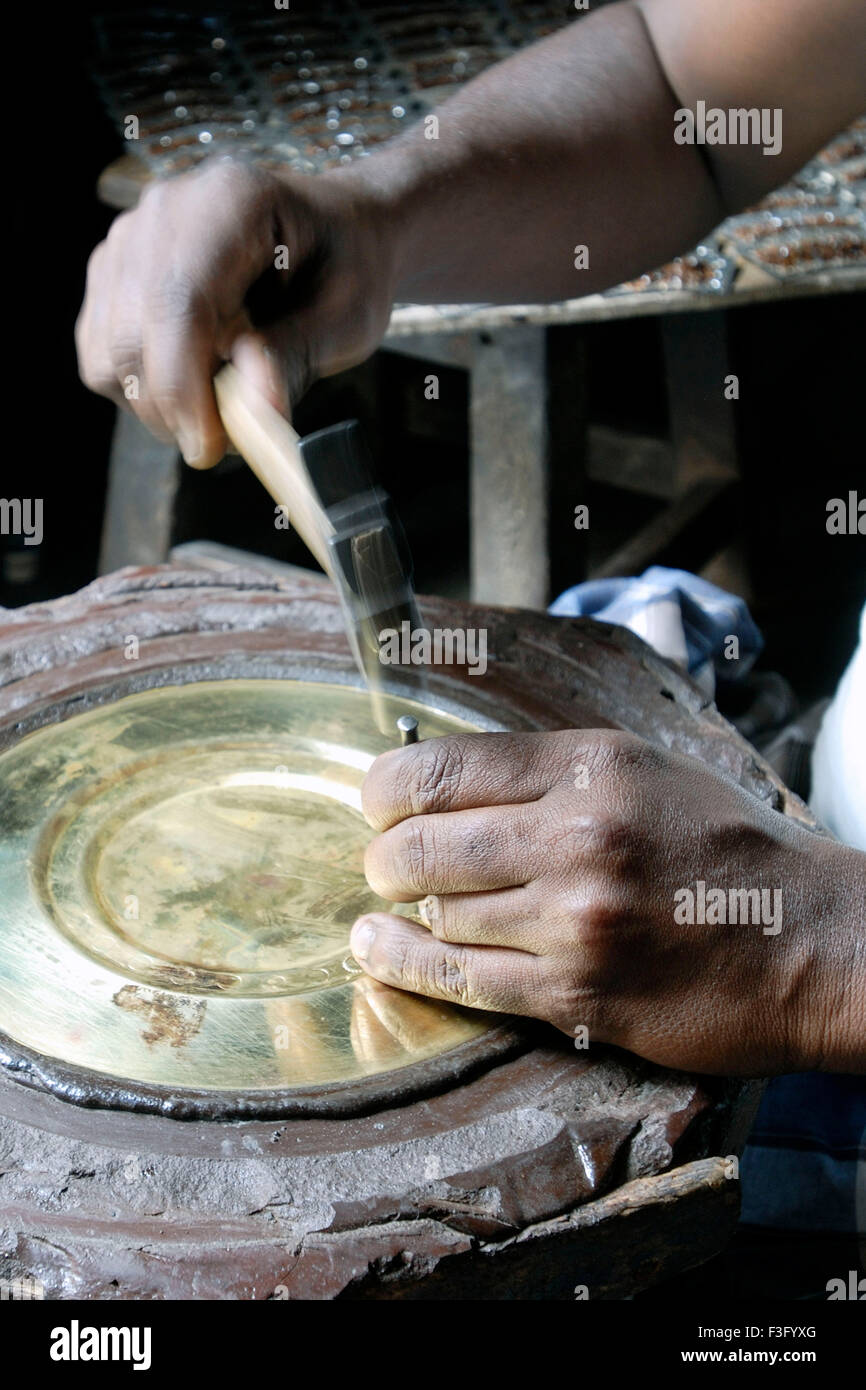 An Artisan making Thanjavur art plate Brass metal plate ; Thanjavur ; Tamil Nadu ; India Stock Photo