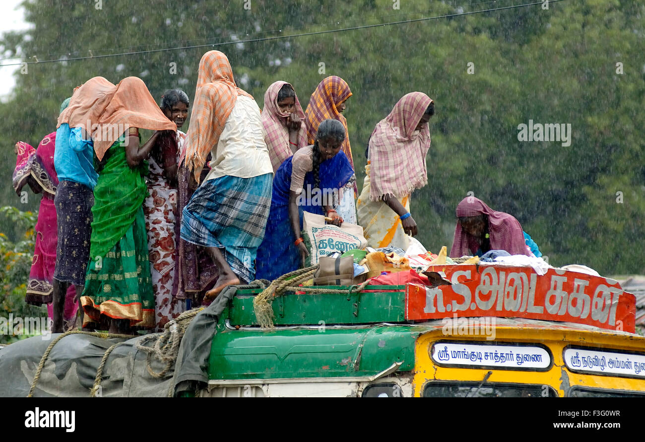 Coolies standing on a lorry top on a rainy day ; Tamil Nadu ; India Stock Photo