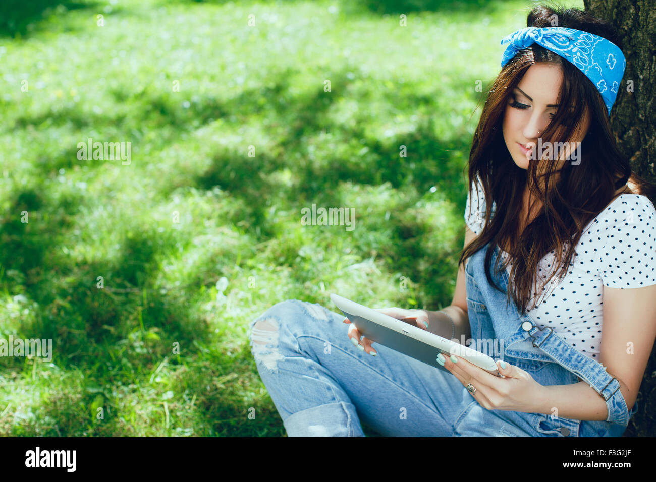 Closeup portrait of pretty girl, sitting in the park, looking