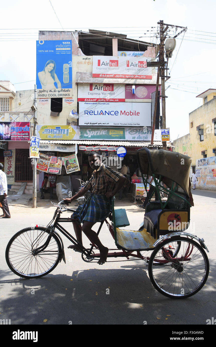 Tricycle rickshaw and rider on street ; District Kanchipuram ; Tamil