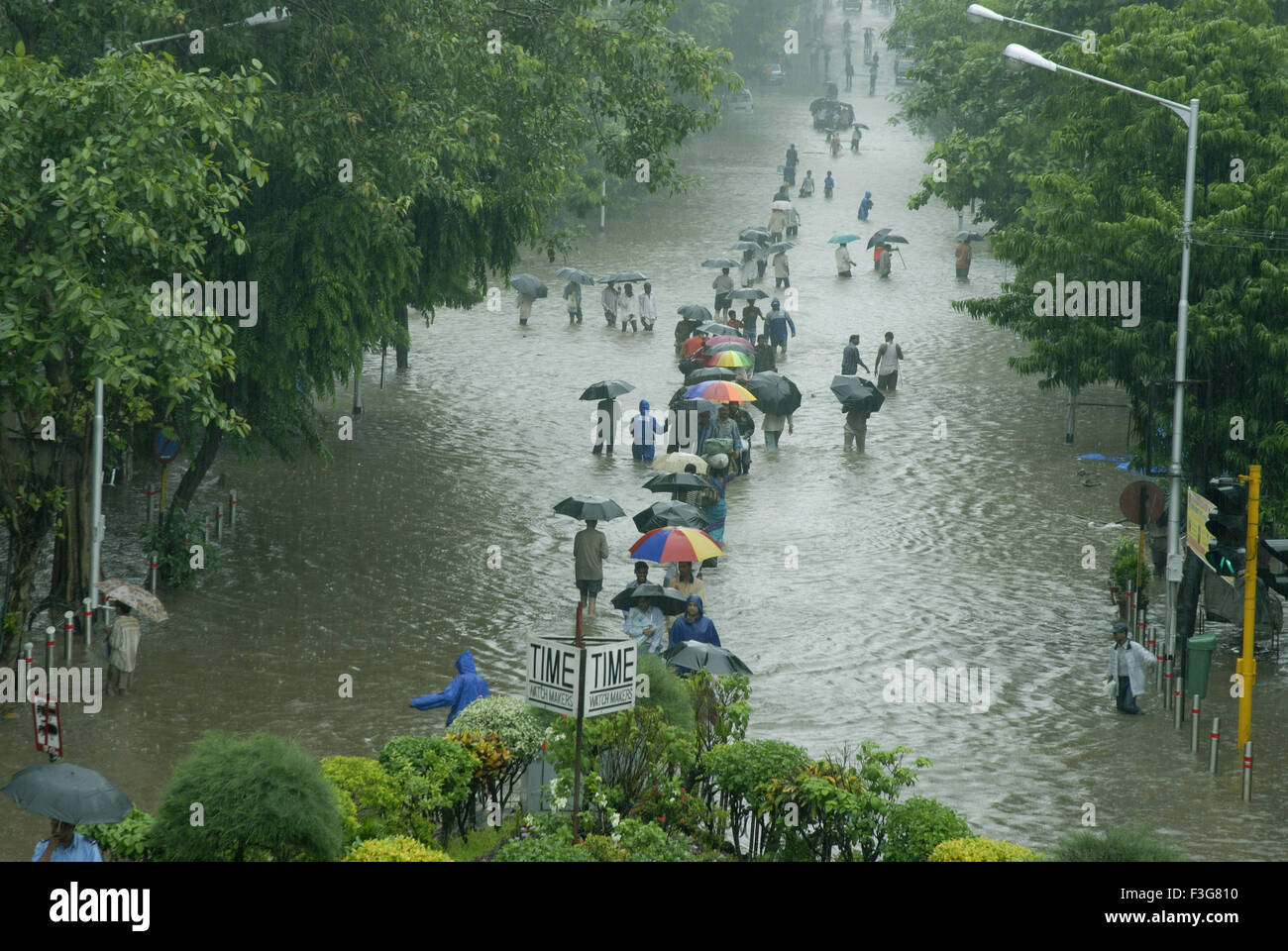 People walking on water logged Dr Ambedkar road due to heavy rain at Dadar ; Mumbai Bombay ; Maharashtra ; India Stock Photo