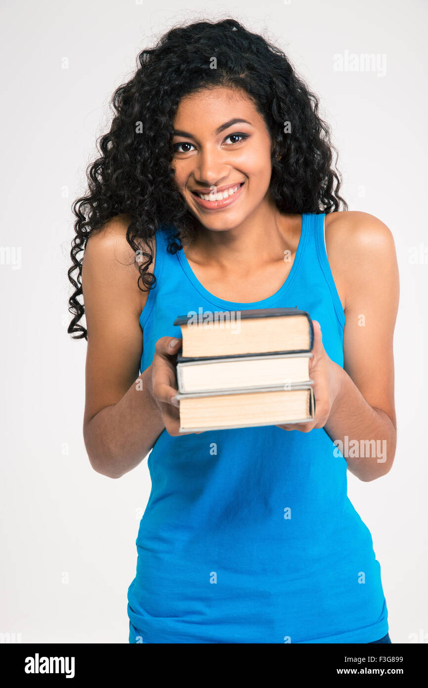 Portrait of a smiling afro american woman holding books isolated on a ...