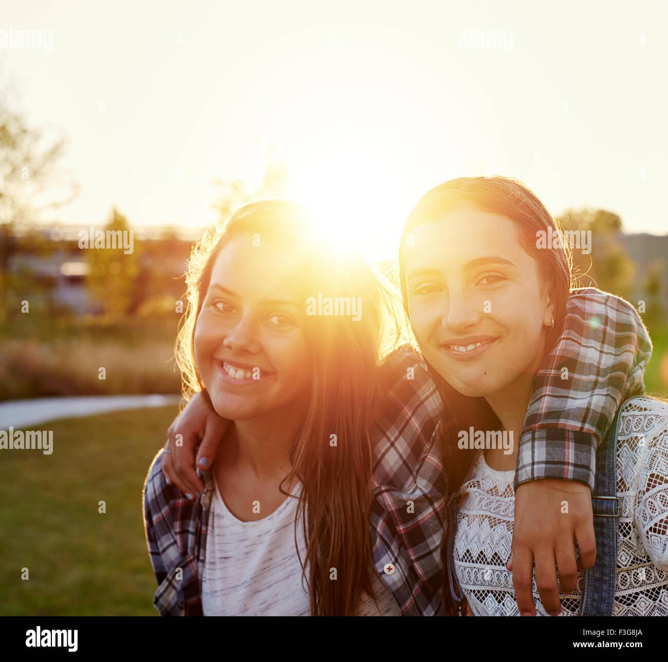 Two teenage girls outside on a summer evening in sun flare Stock Photo