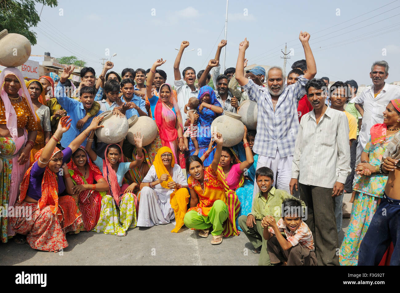 People protesting for water supply and breaking water pot on road