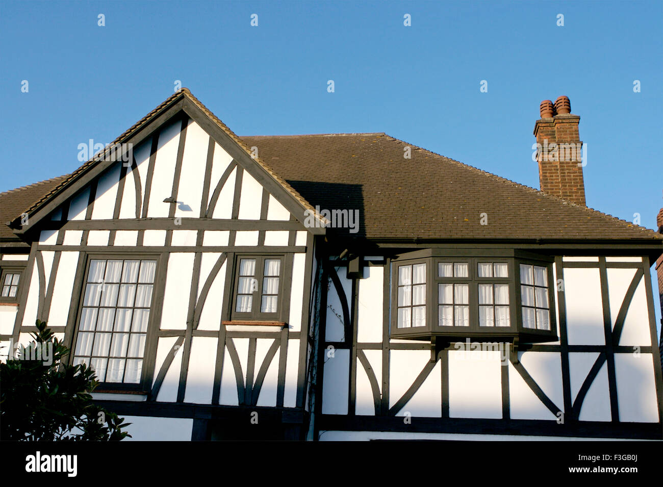 House with white walls and black window and brown roof ; London ; U.K. United Kingdom England Stock Photo