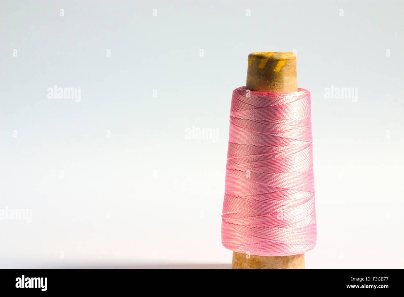 Concept ; one cylindrical shape crochet silky shiny pink Color thread on white background Stock Photo