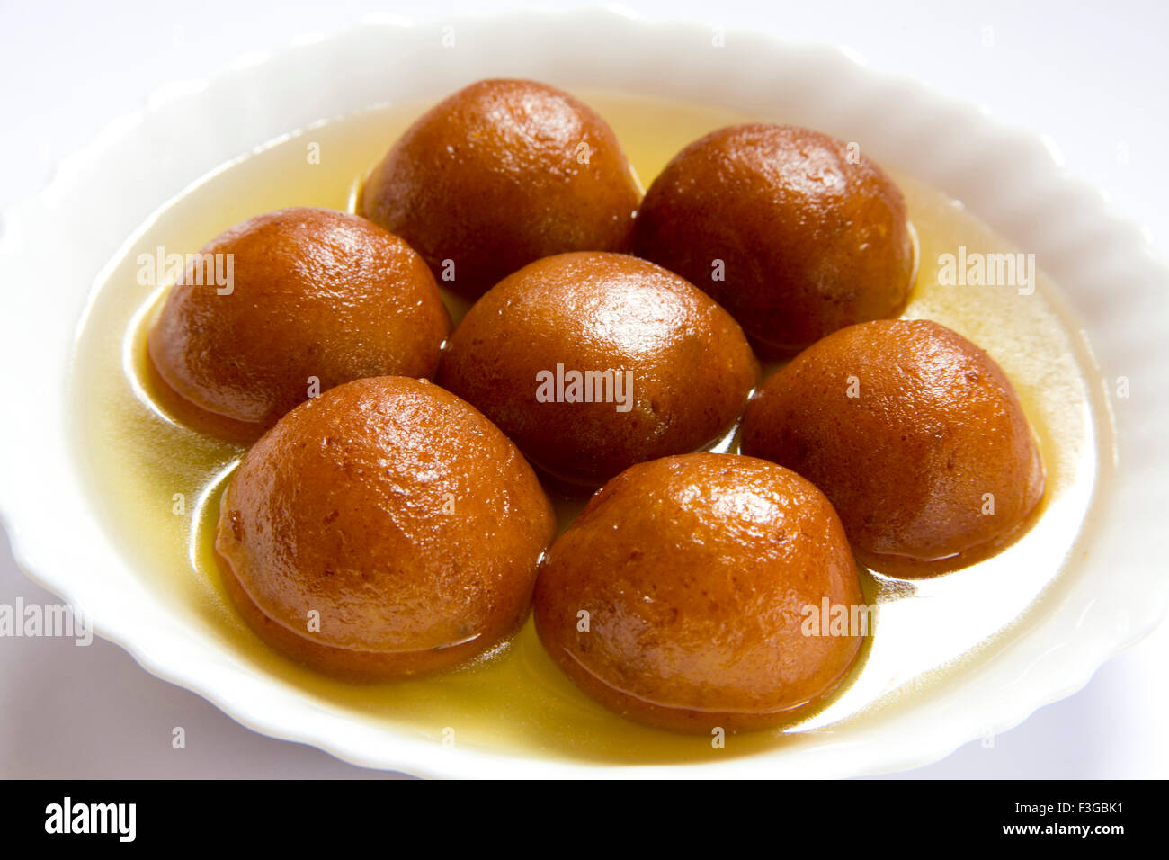 Indian sweet food seven piece of round shape Gulabjamun Bonbon Confectionery with sugar syrup served in plate Stock Photo
