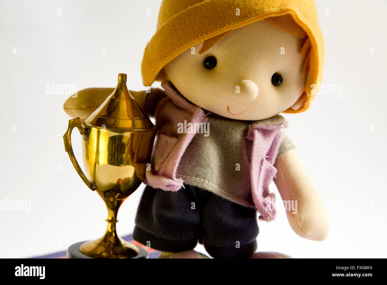 Soft toy boy with trophy on white background Stock Photo