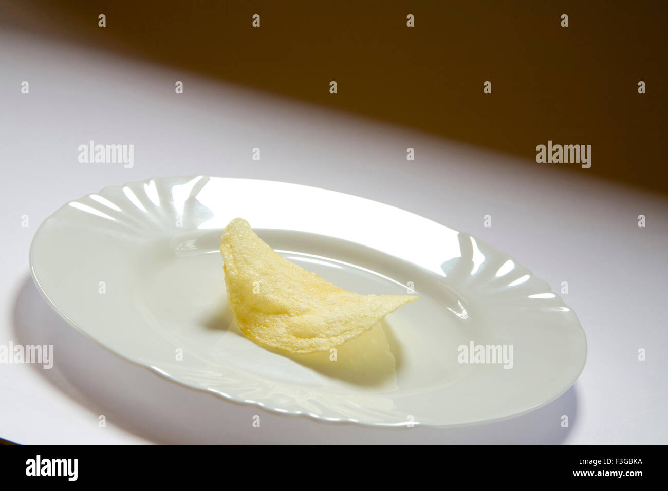 Junk food snacks salty potato chips or wafer served in plate Stock Photo