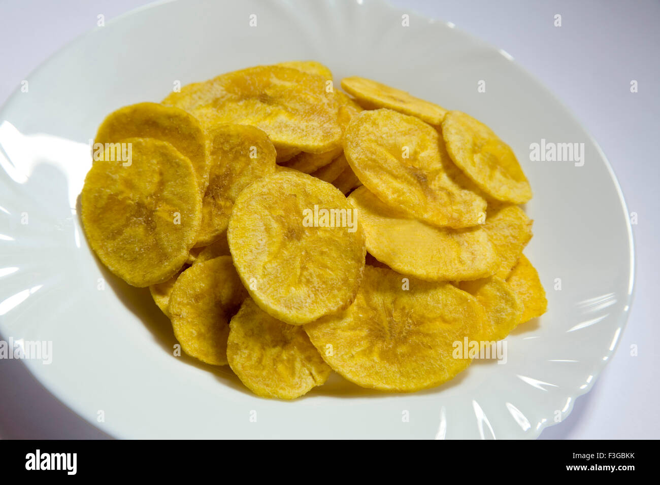 Junk food snacks salty banana chips or wafer served in plate Stock Photo