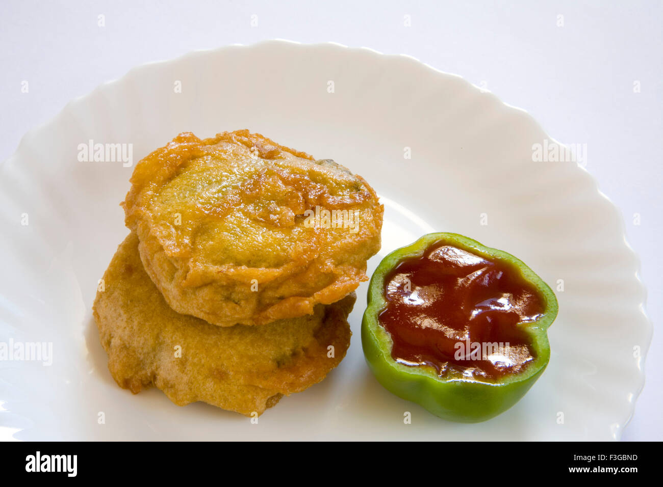 Indian fast food fried batata potatoes vada chopped green chilli served with chutneys tomato ketchup served plate Stock Photo