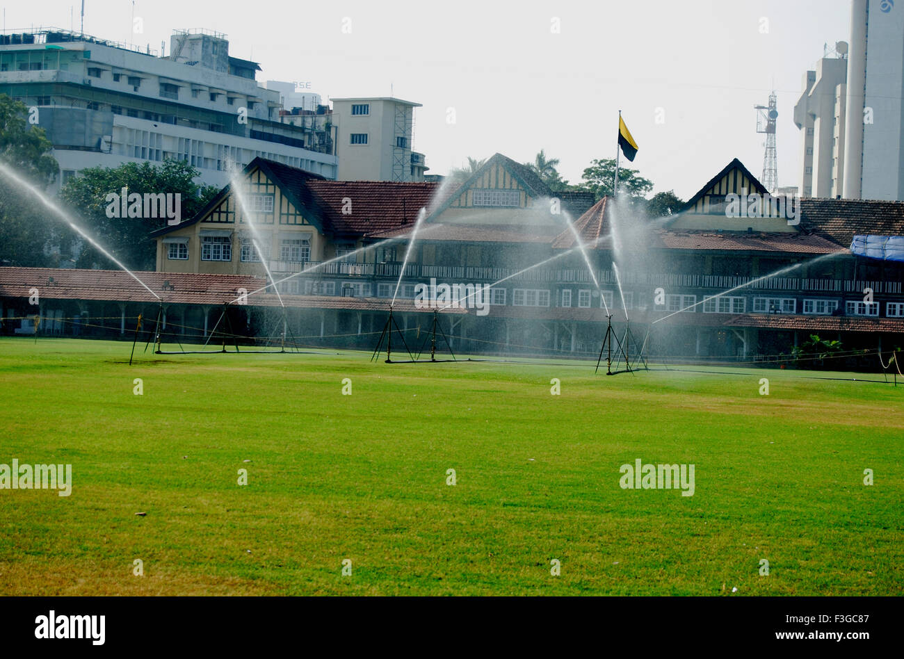 Water sprinklers sprinkling over ground at Mumbai gymkhana ; Bombay Mumbai ; Maharashtra ; India Stock Photo