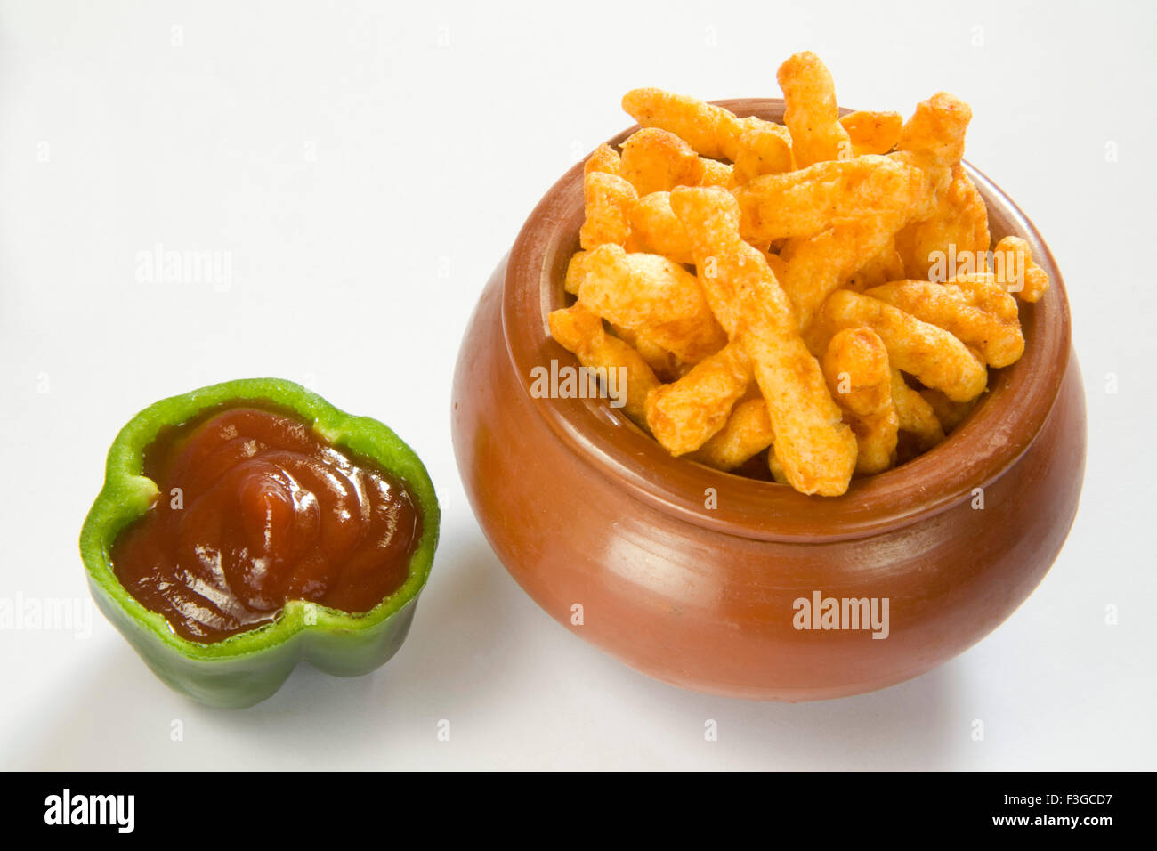 Snack junk food crisp crunchy and spicy deep fry in oil rice flour served tomato ketchup served matka chopped capsicum Stock Photo
