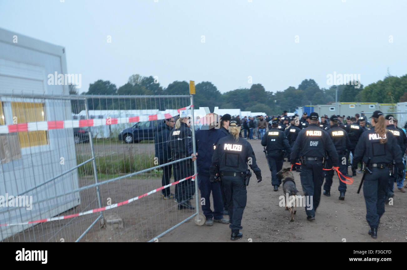 Hamburg, Germany. 06th Oct, 2015. Police special forces enter a refugee reception center with a tracker dog in Hamburg, Germany, 06 October 2015. The State Office of Criminal Investigation is looking into a fight between Albanians and Afghans. This also concerns a lead that an Albanian held two Afghans with at gunpoint. Photo: Frank Bruendel/CityNewsTV/dpa (ATTENTION EDITORS: Re-sent with additional information: A man has been pixelated by the source for legal reasons)/dpa/Alamy Live News Stock Photo