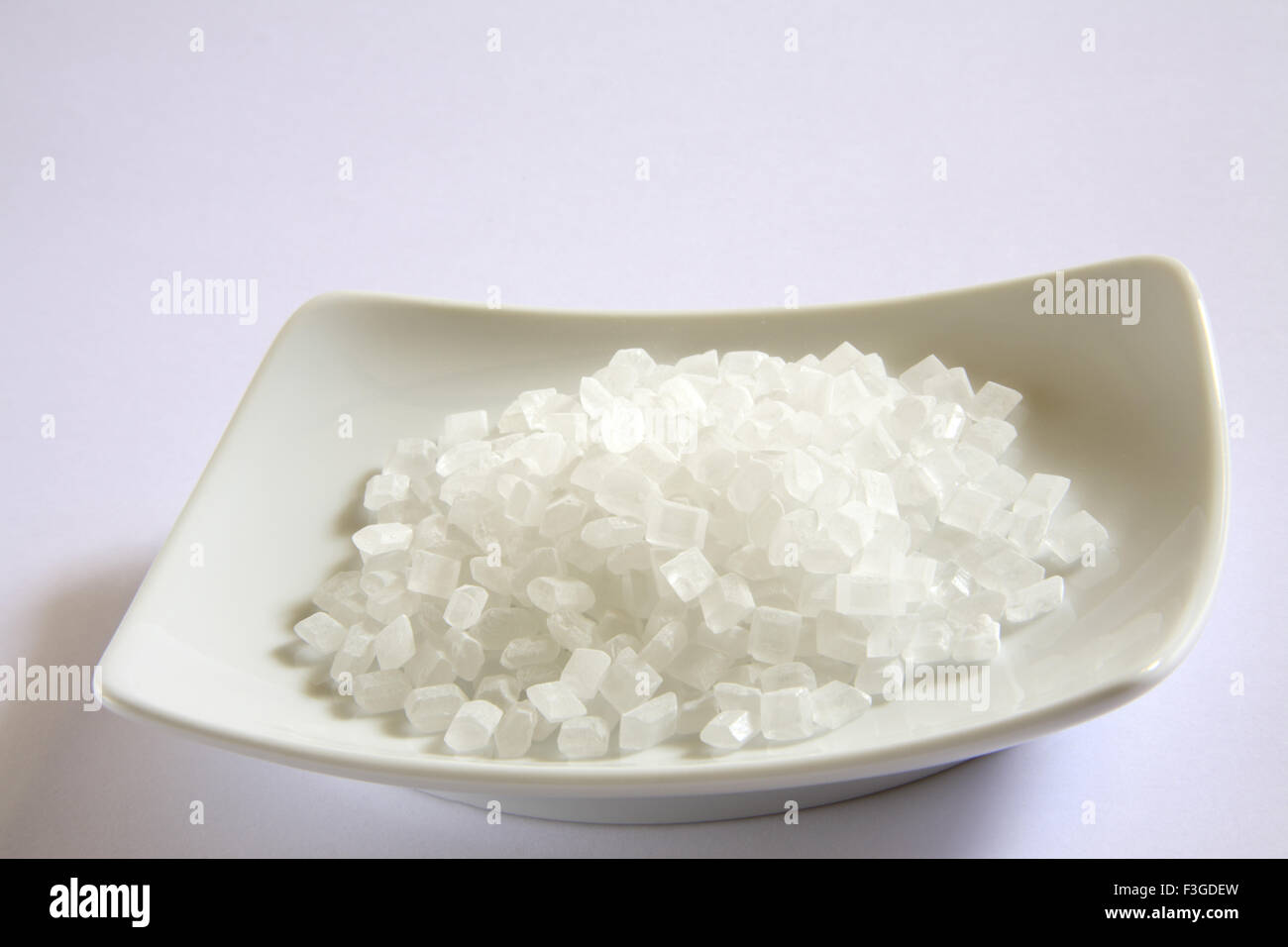 Sweet small sugar cube Khadi Shakker in plate on white background Stock Photo