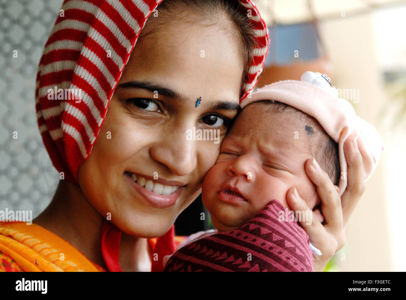 Indian new born baby with mother touching cheeks India MR#364 Stock Photo