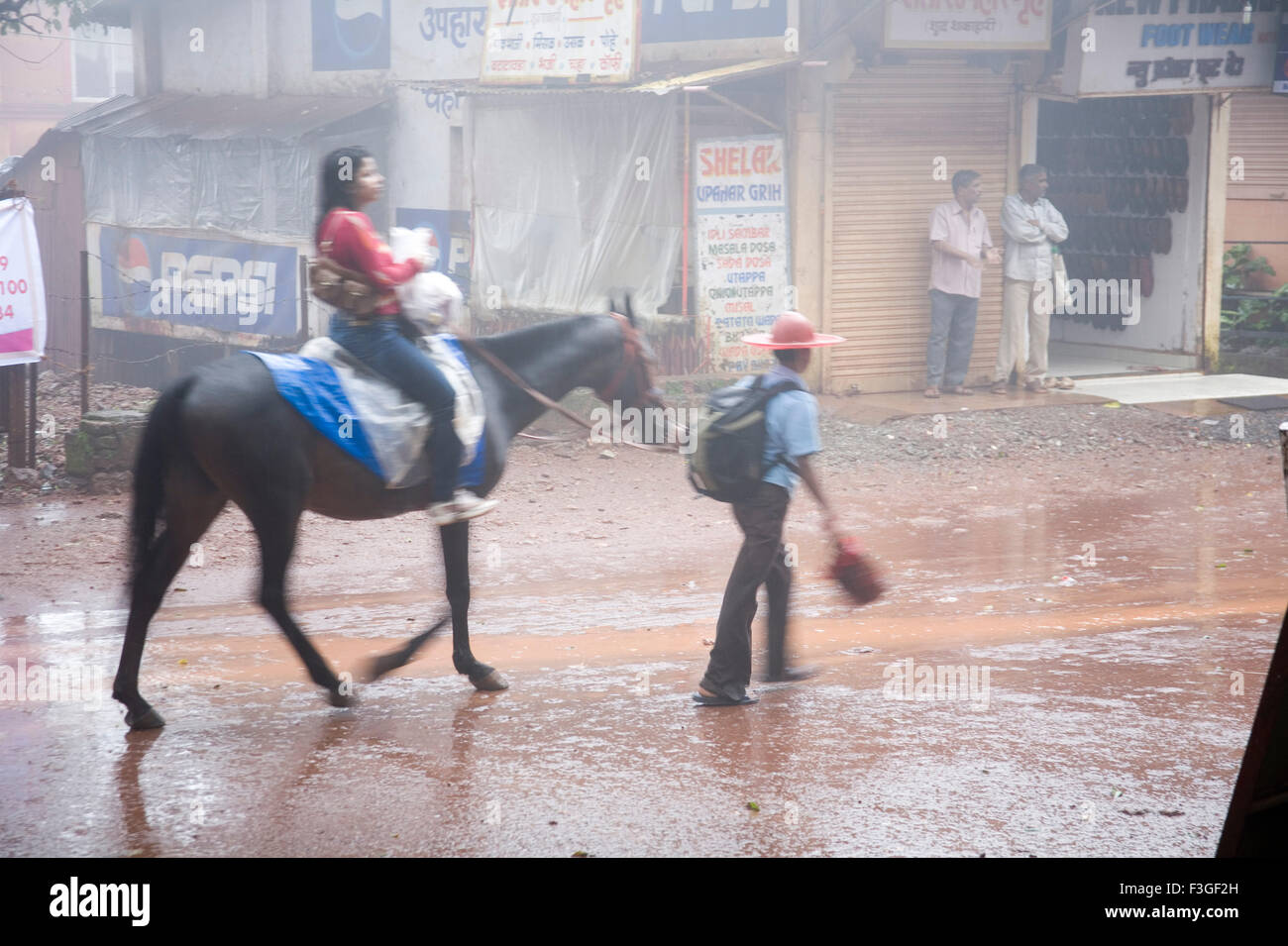 Woman riding horse in monsoon season ; Matheran ; Maharashtra ; India Stock Photo