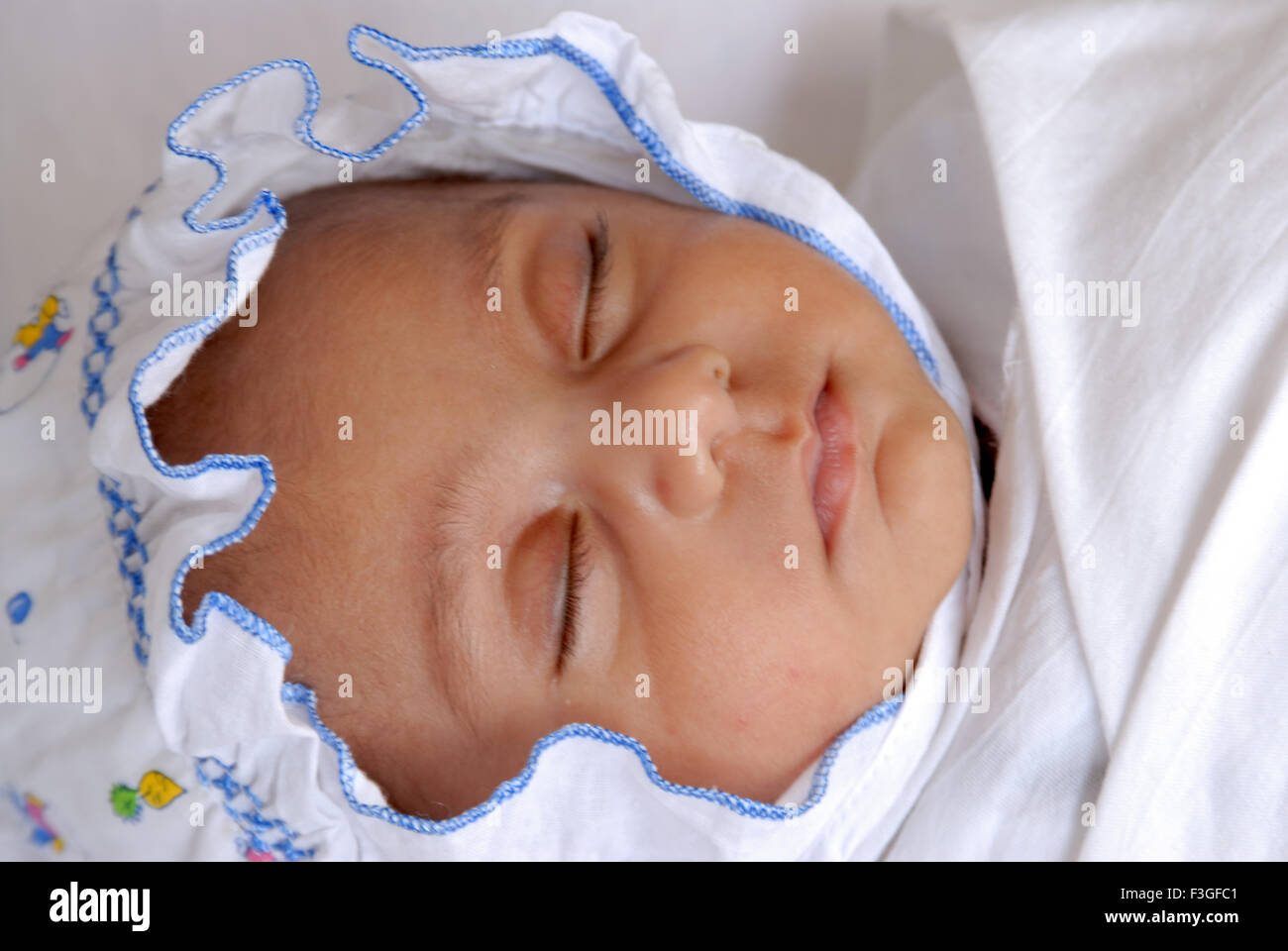 Indian newborn baby child sleeping peacefully with white cap - MR#512 Stock Photo