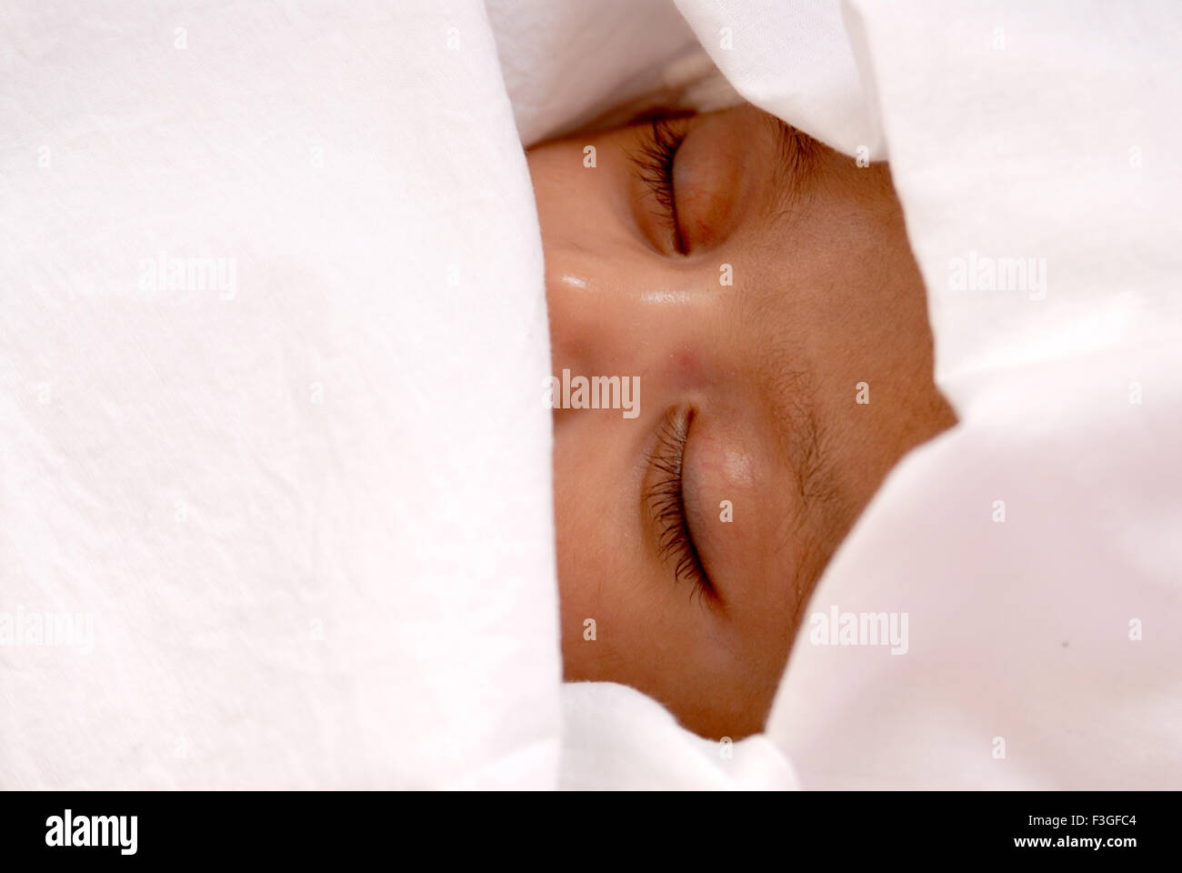 Indian baby girl child sleeping peacefully covered white cloth - MR#512 - rmm 123467 Stock Photo
