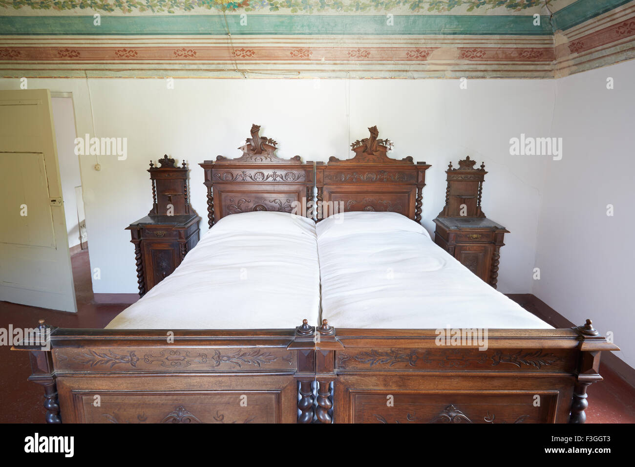 Wooden double bed in ancient Italian house with fresco Stock Photo