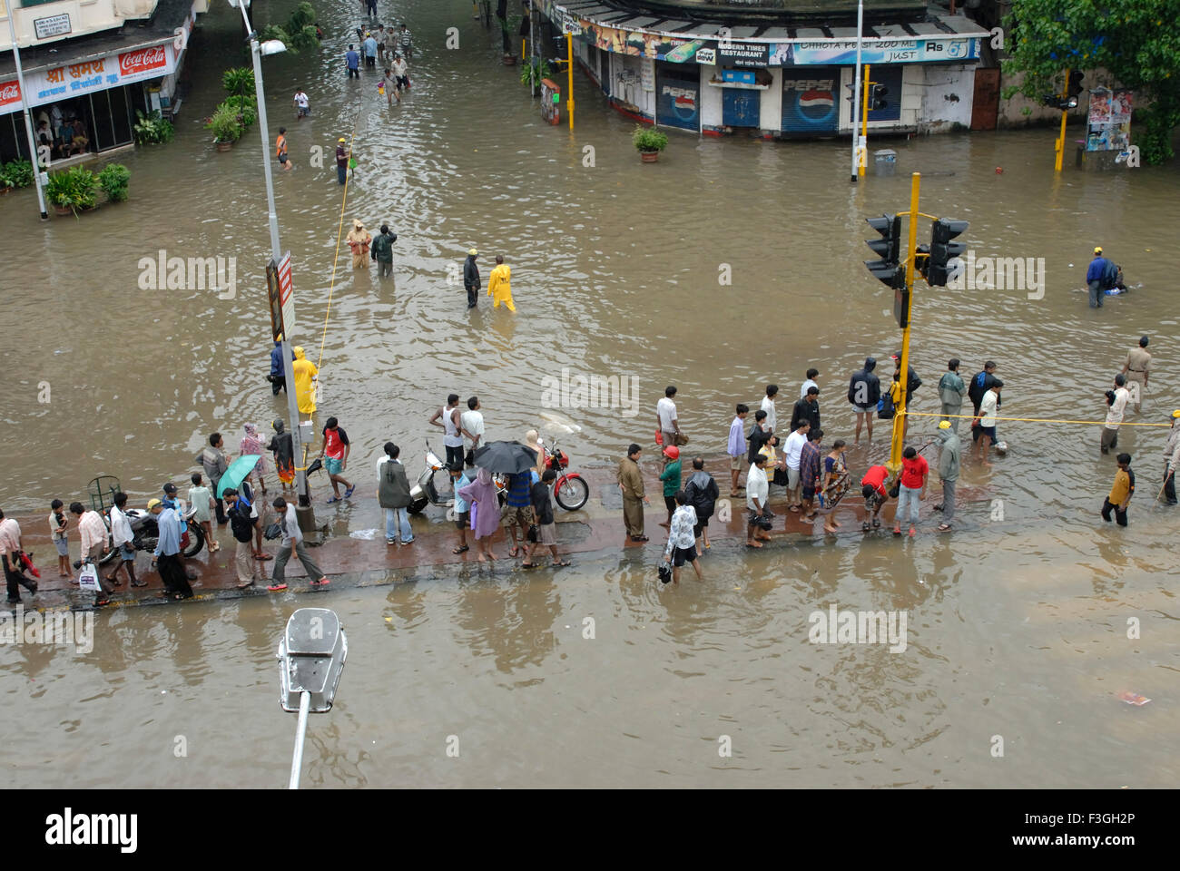 Monsoon ; people walking through flooded road heavy rain in Parel