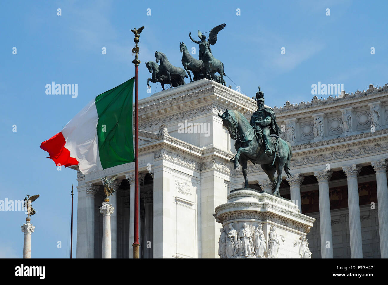 The Italian flag and bronze sculpture of King Emanuele in front of the National Monument to Victor Emmanuel II, Rome. Stock Photo