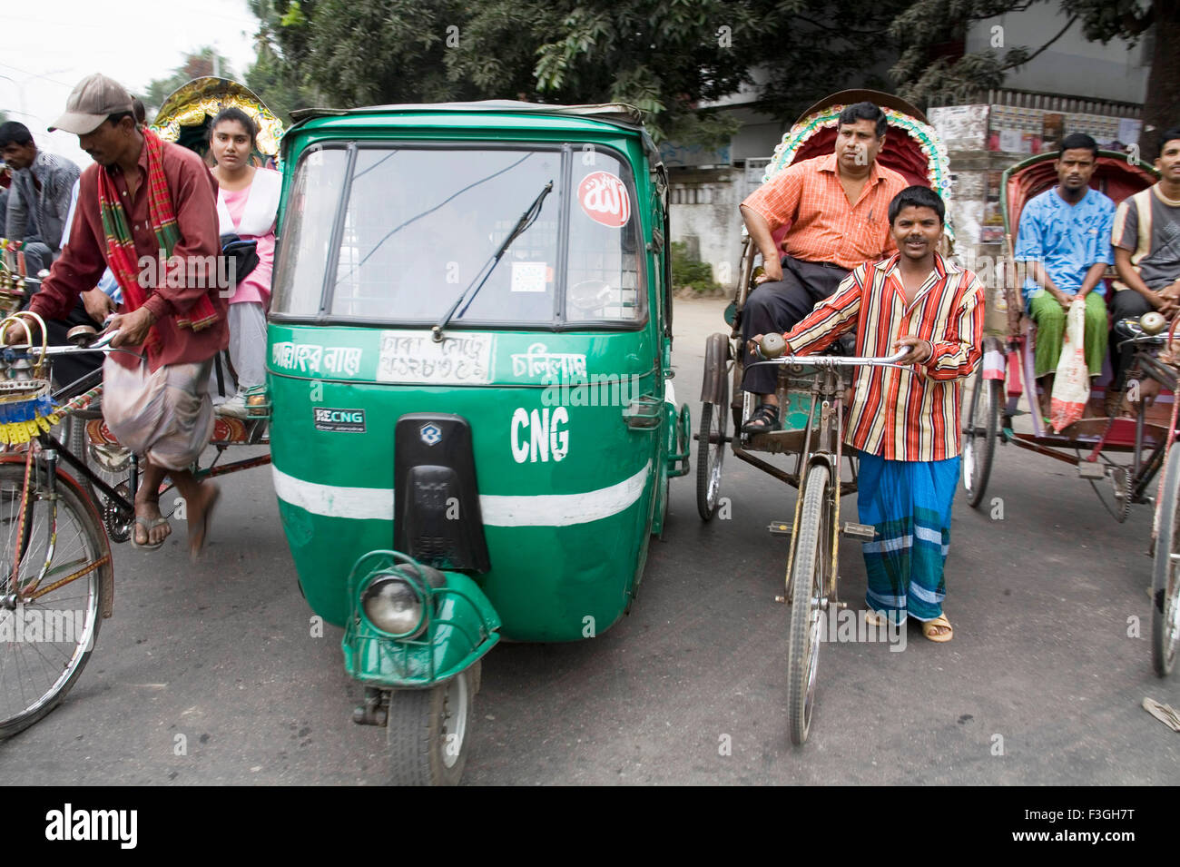Street scene ; Auto Rickshaw tempo and Cycle rickshaw rider with passenger traffic in Dhaka ; Bangladesh Stock Photo