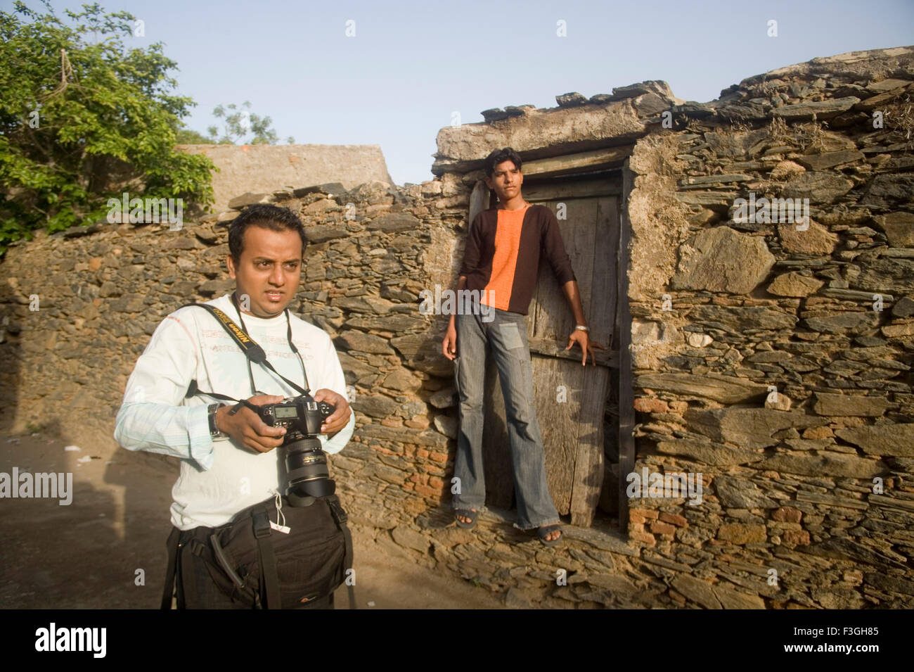 Photo Journalist Atul Loke shooting picture of village muslim boy Akhatar standing stone wall Village Dilwara Rajasthan Stock Photo