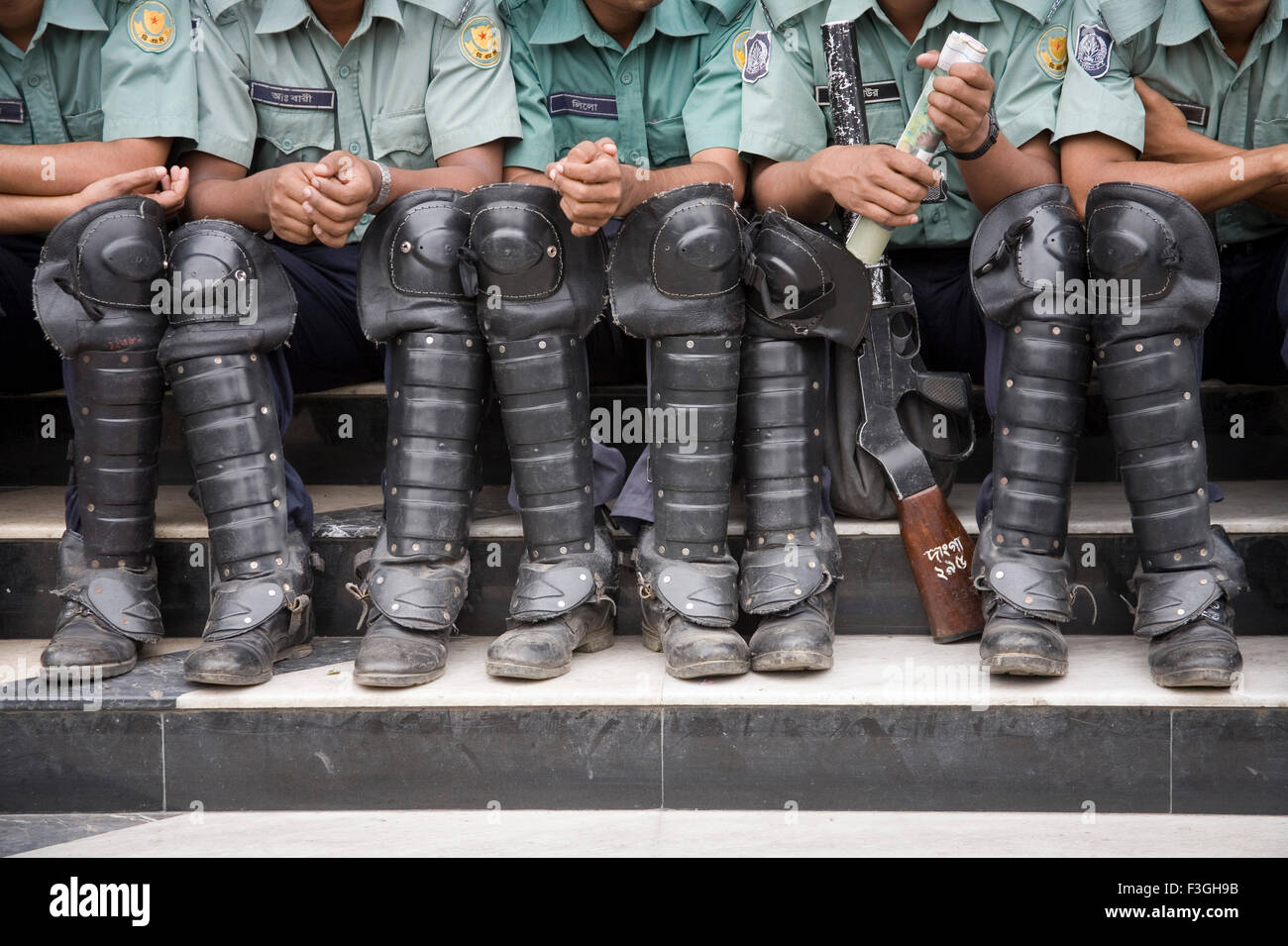Police force ; policemen sitting on staircase wearing black shoes ; Dhaka ; Bangladesh Stock Photo